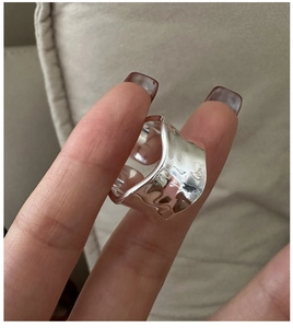 Macro shot of silver wave ring featuring irregular hammered texture and wide band style
