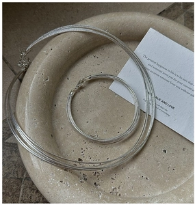 Detailed view of silver multi-strand snake chain necklace and bracelet on a stone tray