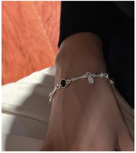 Detail of S925 sterling silver bracelet with black onyx beads and wired texture on wrist