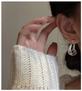 Macro shot of S925 sterling silver multi-layer twisted hoop earrings on model