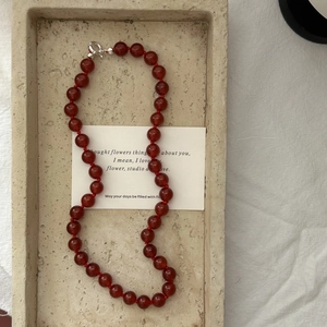 S925 sterling silver red agate beaded necklace on a minimalist stone display tray
