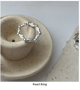 Dettaglio anello in argento S925 con perline marquise e tonde su base in ceramica beige