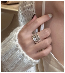 Detailed close-up of layered silver ring featuring a sparkling round center stone