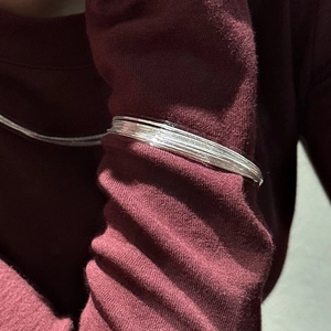 Italian S925 sterling silver multilayer sparkling bangles on red knitwear sleeve