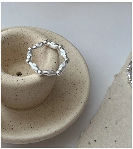Dettaglio macro di anello con perline in argento S925 e trama lavica su ceramica
