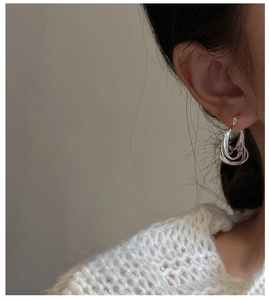 Close-up of S925 sterling silver earrings with a layered oval woven rope texture design