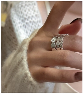 Macro shot of S925 silver layered ring with hammered texture on model hand