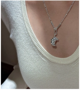 Macro shot of S925 sterling silver croissant pendant on a delicate chain necklace