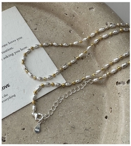 Detail of S925 sterling silver two-tone beaded necklace with polished gold and silver beads