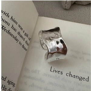 Detailed view of silver S925 ring with wide irregular wave texture and liquid metal finish