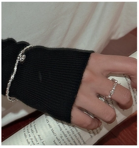 Dettaglio del bracciale con ciondolo a cuore in argento S925 e anello irregolare indossato
