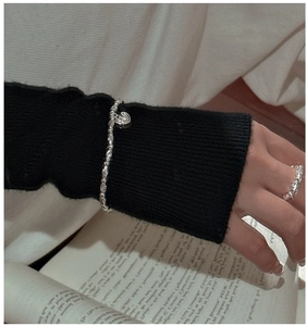 Detail of S925 sterling silver beaded bracelet with heart charm and textured ring