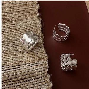 Macro detail of triple-layered S925 sterling silver rings with hollow circular textures