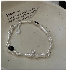 Detail of vintage S925 silver bracelet with black agate stones on a ceramic tray
