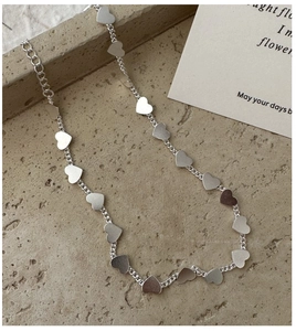 Detailed close-up of S925 silver heart pendant necklace on textured stone background
