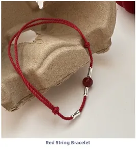 Macro detail of red rope bracelet with silver bamboo beads and red agate gemstone