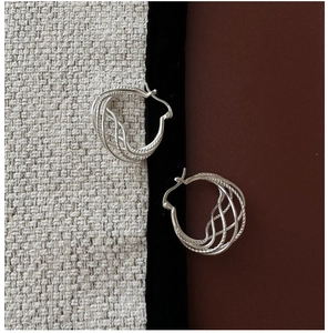 Detailed view of silver S925 earrings with a multi-strand twisted mesh texture design