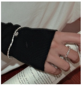 Detailed shot of beaded S925 silver bracelet with heart pendant and matching ring on model