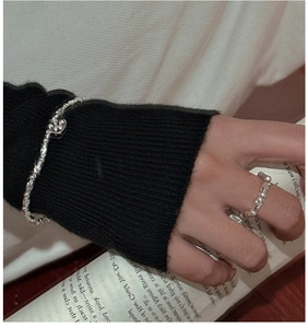 Dettaglio dell'anello in argento S925 e bracciale con ciondolo a cuore sulla mano