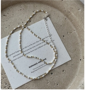 Macro view of two-tone S925 sterling silver beaded necklace with lobster clasp and chain