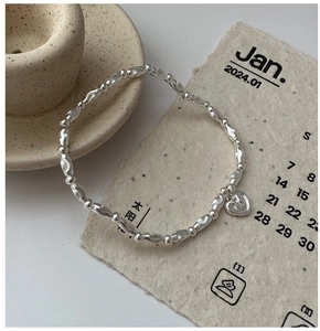 Close-up of S925 sterling silver beaded bracelet featuring a textured heart charm