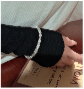Detail of S925 sterling silver braided texture cuff bracelet worn over a black sleeve