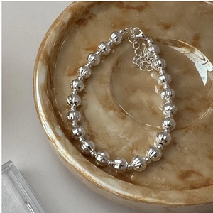 Dettaglio della collana di perle in argento S925 con texture CNC su piatto di marmo