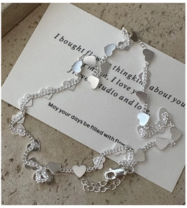 Close-up of S925 silver heart necklace showing matte finish charms and lobster clasp