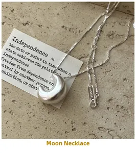 Detail view of S925 sterling silver moon pendant with AG925 hallmark on a box chain