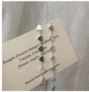 Detailed macro view of S925 silver long fringe earrings with small matte heart sequins