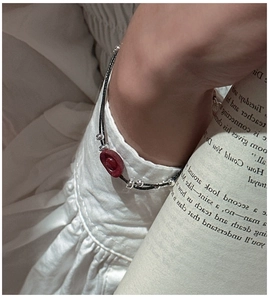 Close-up of S925 silver cinnabar red bead bracelet with black woven cord on wrist