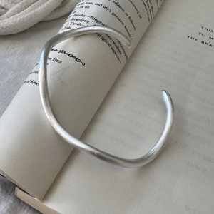 Minimalist S925 sterling silver wave texture cuff bangle on an open vintage book