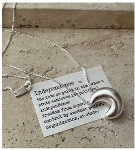 Macro detail of a minimalist S925 sterling silver hollow moon pendant on a delicate chain
