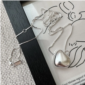 Close-up of S925 sterling silver stamp on minimalist matte finish bean necklace
