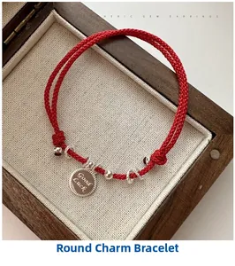 Detail of red braided silver bracelet with Good Luck charm in a vintage wooden box