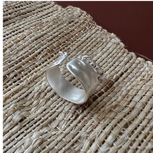 Dettaglio anello largo in argento 925 opaco con catena sottile e punzonatura S925