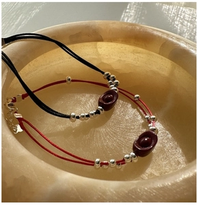 Macro shot of S925 silver red rope bracelet with cinnabar sycee charm and lobster clasp