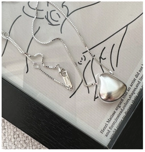 Close-up of S925 sterling silver bean pendant with polished finish on a box chain