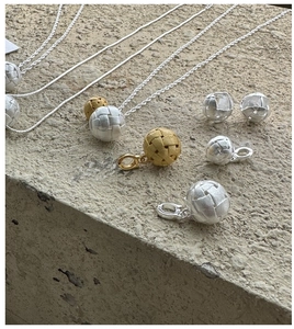 Detail van geweven S925 zilveren balhangers en oorbellen in goud en zilveren uitvoering
