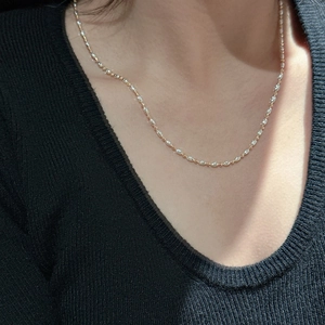 Minimalist S925 sterling silver two-tone chain necklace worn on a black V-neck sweater