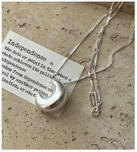 Detail of S925 sterling silver hollow moon pendant with AG925 stamp on a box chain