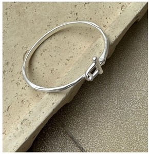 Gros plan du poinçon S925 sur le bracelet jonc mat au design fer à cheval minimaliste