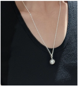 Detail van een S925 sterling zilveren balhanger aan een gedraaide touwketting collier