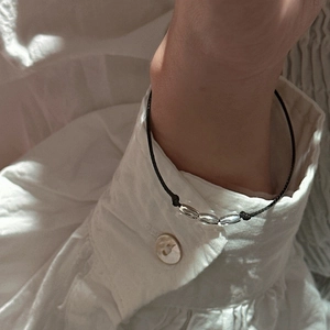 Minimalist S925 sterling silver bead bracelet with thin black cord on woman's wrist