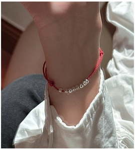 Close-up of red braided rope bracelet with eight S925 sterling silver beads on a wrist