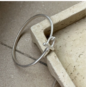 Détail macro du bracelet boucle fer à cheval en argent avec texture brossée mate