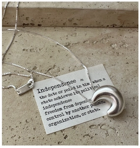 Detail of S925 sterling silver crescent moon pendant with box chain on stone surface