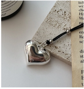 Macro detail of S925 sterling silver heart pendant with authentic metal hallmark stamp