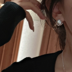 Elegant S925 sterling silver woven ball hoop earrings worn by a model in a retro style