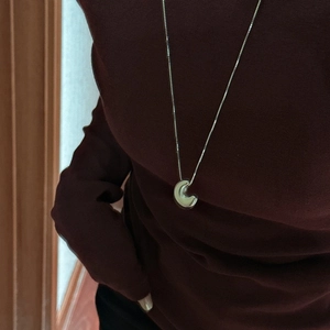 S925 sterling silver hollow moon necklace with minimalist pendant on a burgundy turtleneck